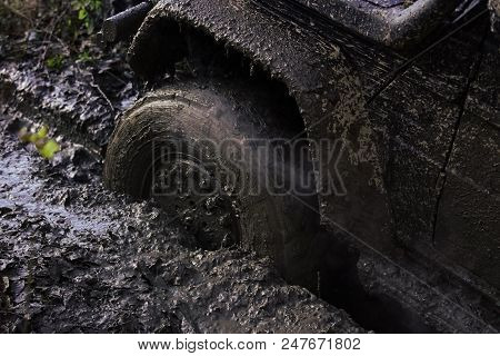 Offroad. Wheel With Little Cloud Of Smoke, Defocused. Fragfment Of Car Stuck In Dirt, Close Up. Dirt