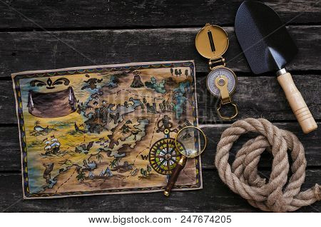 Treasure Map, Compass, Shovel, Mignifying Glass And Rope On Old Wooden Table Background. Treasure Hu
