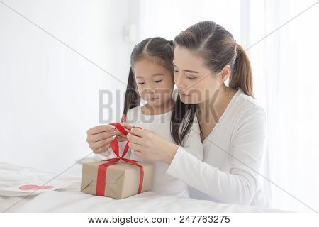 Attractive Asian Girl Received A Present From Her Mom. Woman Try To Open Gift For Her Daugther. Happ
