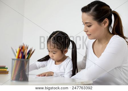Attractive Little Girl Writing Book. Mom Teaching Her At Home. Children Lifestyle, Education Concept