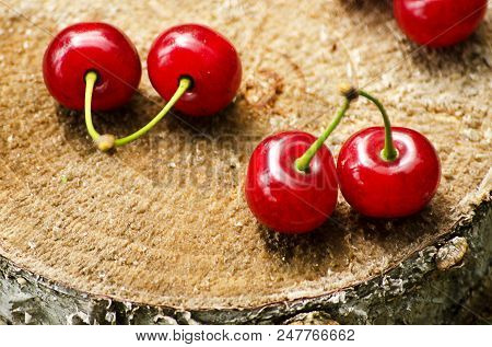 Red Ripe Cherry On A Background Of Trees And The Sun