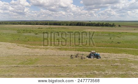 Aerial, View Agricultural Machinery With Wheeled Rake Makes Ranks Beveled Hay.tractor Which Is Linin