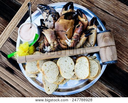 Plate With Boiled Legs And Claws Of Brown Crab With Bread And Dip On Rustic Wooden Table