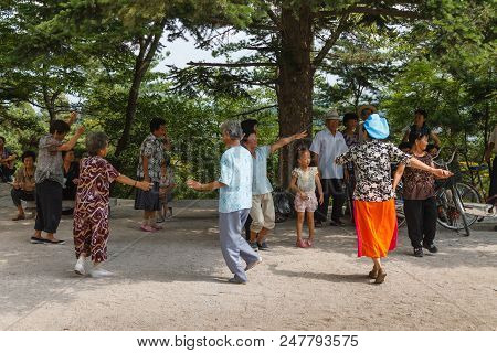 Kaesong, North Korea-july 30, 2014: Korean Elderly People Are Dancing In The Kaesong City Park.