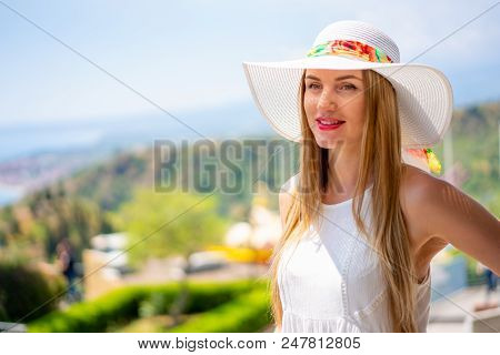 Beautiful Girl In A Shite Dress And Summer Hat Exploring The Old Town Of Taormina On Sicily Island.