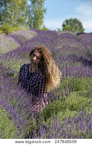 Ostrow, Poland - June 6, 2018: Beautiful  Woman With Long Curly Hair In The Middle Of A Lavender Fie