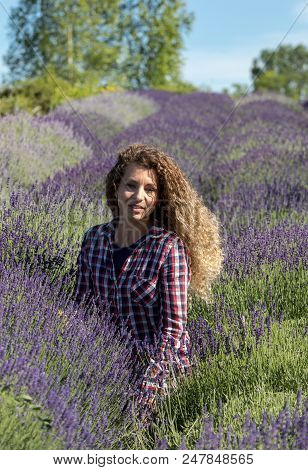 Ostrow, Poland - June 6, 2018: Beautiful  Woman With Long Curly Hair In The Middle Of A Lavender Fie