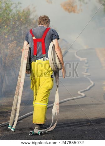 Melbourne, Australia - April 13, 2018: Fire Fighter With Rolls Of Fire Hose At A Bush Fire In An Sub