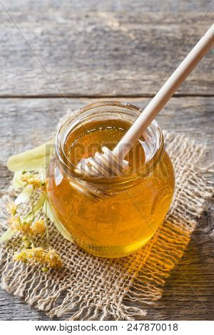 Glass Jar Of Honey, Linden Flowers On Wooden Background