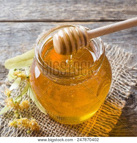 Glass Jar Of Honey, Linden Flowers On Wooden Background