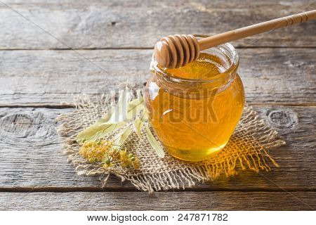 Glass Jar Of Honey, Linden Flowers On Wooden Background