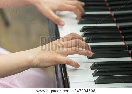 Children's Hands Are Playing The Piano. Child's Hand On Piano Keys.