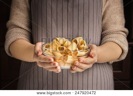 Closeup Of Unknown Woman Holding Glass Bowl With Yellow Raw Mezzi Pasta