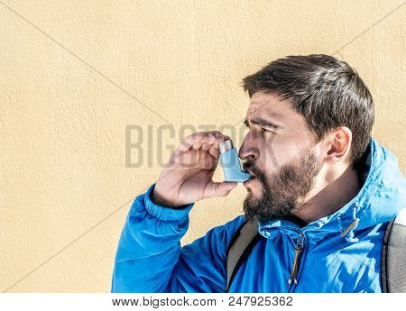 Portrait Of Young Man Using Asthma Inhaler Outdoor