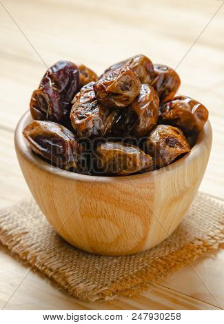 Dried Dates Plam Fruit In Wooden Bowl On Table