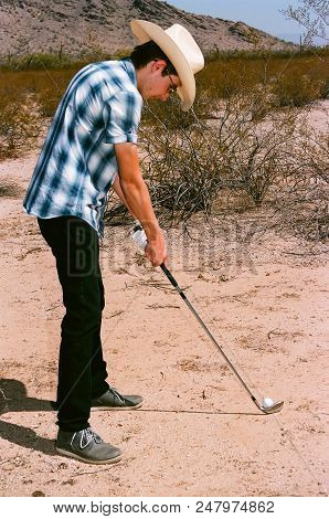Young Boy In Natural Terrain Desert Golfing