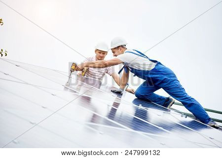 Construction Worker Connects Photo Voltaic Panel To Solar System Using Screwdriver. Professional Ins
