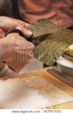 Sushi Roll Demonstration On How To Place Ingredients For An Outside Sushi Roll, With Rice And Seawee