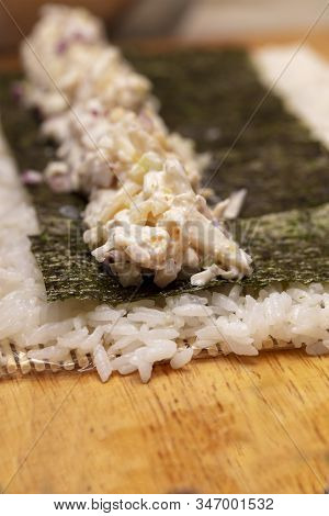Sushi Roll Demonstration On How To Place Ingredients For An Outside Sushi Roll, With Rice And Seawee