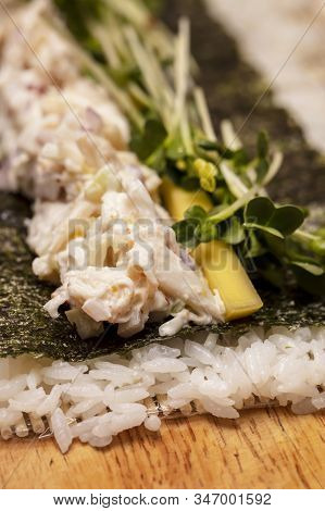 Sushi Roll Demonstration On How To Place Ingredients For An Outside Sushi Roll, With Rice And Seawee