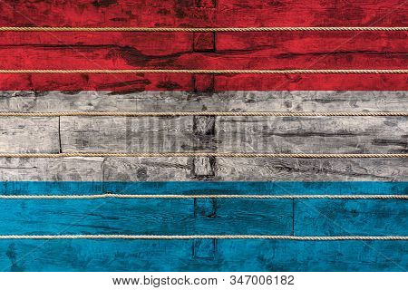 National Flag  Of Luxembourg On A Wooden Wall Background. The Concept Of National Pride And A Symbol