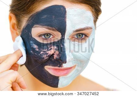 Woman With Clay Carbo Black Mask On One Half Face And White Mud On Second Half. Girl Removing Cosmet
