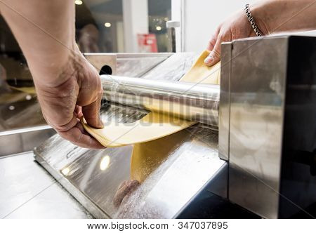 Chef Rolling Dough With A Pasta Machine. Pasta Maker Machine.