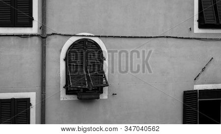 A Window With Semi Opened Blinders On A Wall