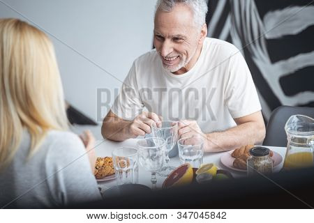 Mirthful Man Laughing At The Table Stock Photo