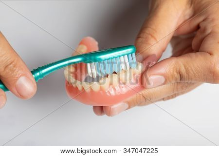 Carefuly Cleaning Dental Prothesis With Toothbrush