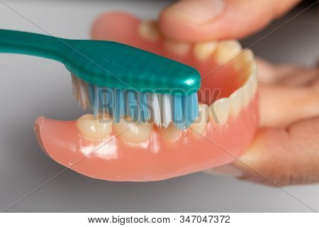 Cleaning Denture Or Dental Prothesis With Toothbrush