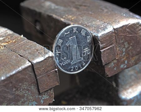 Yuan Coin Clamped In A Metal Vise. Currency Under The Onslaught, The Concept Of Financial Problems A