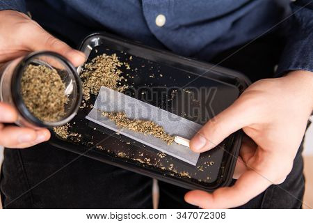 Man Rolling A Marijuana Joint. Man Preparing And Rolling Marijuana Cannabis Joint. Close Up Of Addic