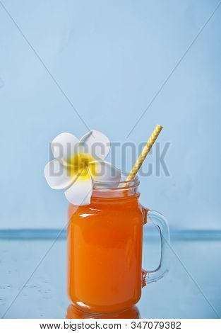 Glass Of Tropical Exotic Multifruit Juice Cocktail Drink With Plumeria Frangipani Flower For Decorat