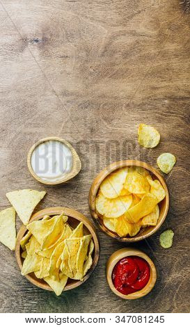 Table Fof Tasty Snacks And Beer Prepared For Watching Sports On Tv. Wooden Background. Top View. Fla