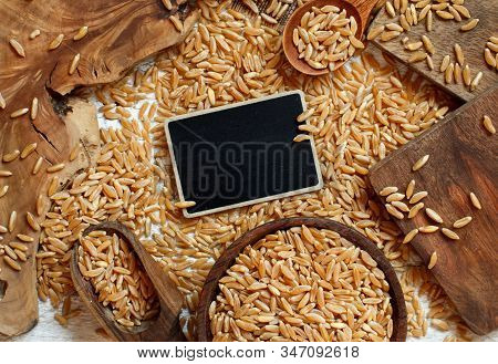 Raw Kamut Grain With A Small Chalkboard Top View