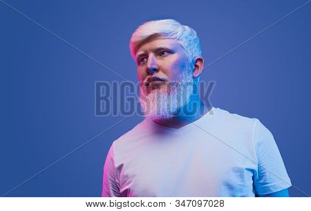 From Below Of Serious Confident Bearded Male With Albinism Wearing Whit T Shirt Standing In Studio W