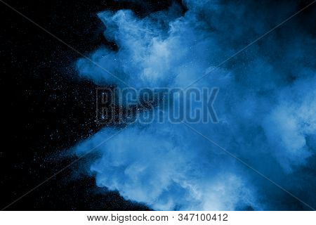 Abstract Art Blue Powder On Black Background.