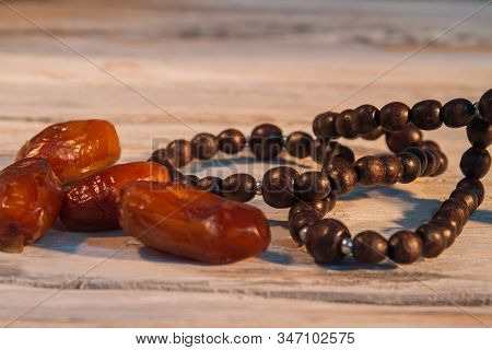 Bunch Of Dates And Bead Necklace Close Up. Wooden Bavckground.