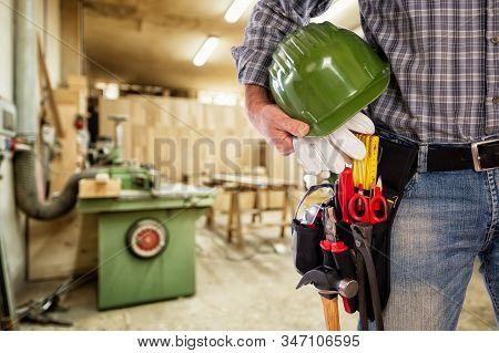 Close-up. Carpentier With Helmet And Leather Gloves In Hand. Construction Industry, Carpentry Worksh