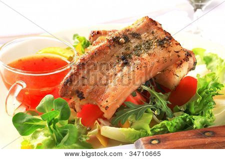 น้ำกับหมูสามชั้นที่ทอดบนผักกาดหอมมะเขือเทศสดและมะนาว