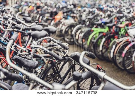 Blurred Background Of Different Bicycles In The Parking Lot. Parked Bicycles In Amsterdam