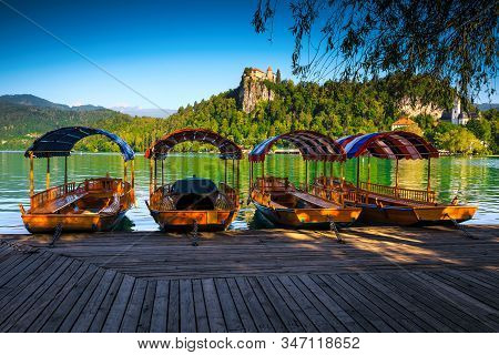 Traditional Touristic Wooden Pletna Boat Moored At The Pier. Pletna Rowing Boat On The Alpine Bled L