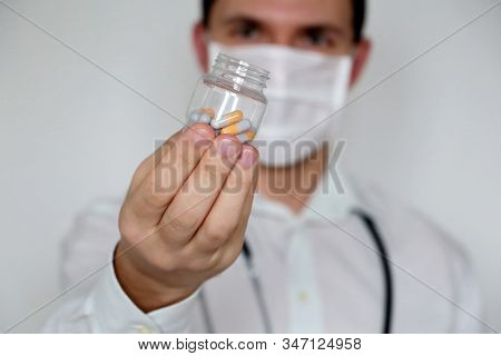 Doctor Giving Pills, Physician In Medical Mask With Bottle Of Capsules. Concept Of Dose Of Drugs, Vi