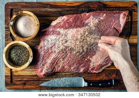 Seasoning A Beef Brisket With Salt And Pepper Before Barbequing On A Smoker