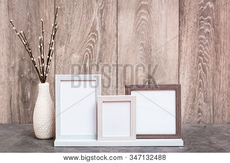 Ready Mock Up. Three Empty Photo Frames On The Stand And A Vase With Artificial Willow Branches Are 