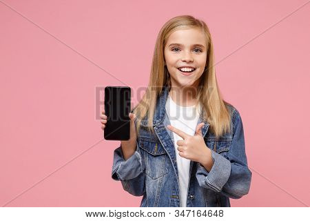 Little Kid Girl 12-13 Years Old In Denim Jacket Posing Isolated On Pastel Pink Background. Childhood