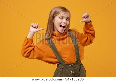 Cheerful Little Blonde Kid Girl 12-13 Years Old In Turtleneck Jumpsuit Isolated On Orange Yellow Wal
