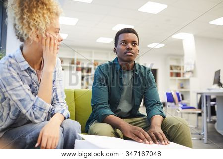 Portrait Of Young African-american Man Reading Braille While Studying With Seeing Friend In School L