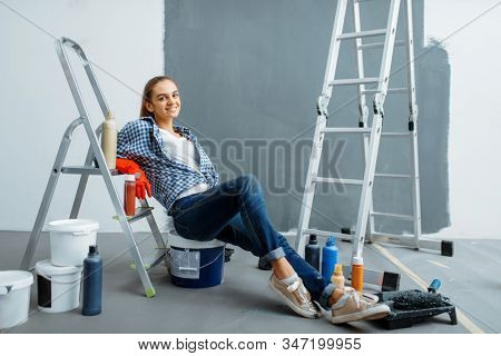 Female house painter relaxing on a lagger